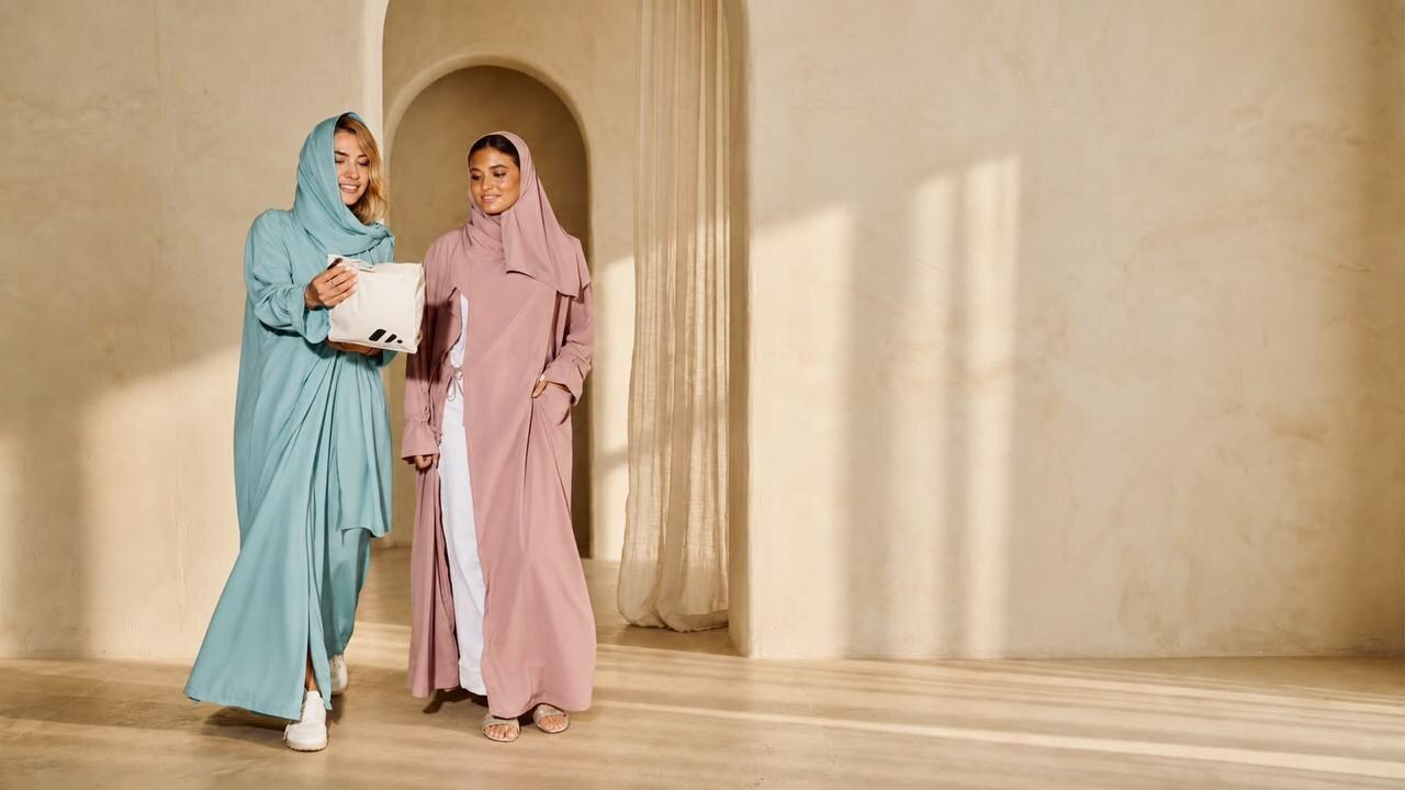 Woman in a dusty rose Prayeasy prayer abaya in a sunlit limestone interior